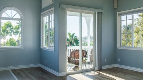 Trendy modern interior of a living room with blue walls and white windows